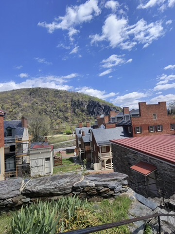 Harpers Ferry rooftops with mountain backdrop under blue sky
