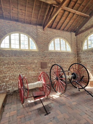 Historic fire house at Mount Vernon with red-wheeled fire hose cart